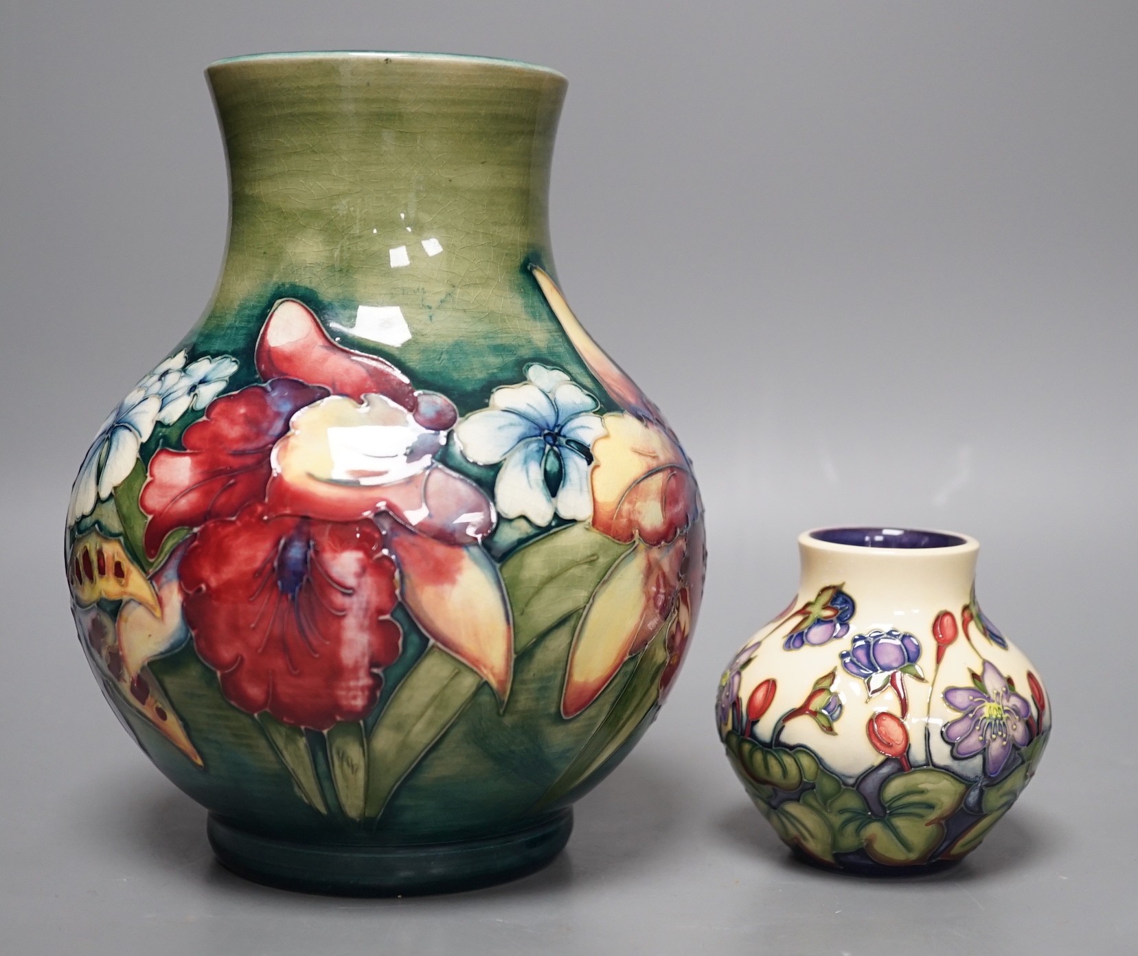 A Moorcroft orchid pattern vase and another smaller vase, orchid vase 19cms high